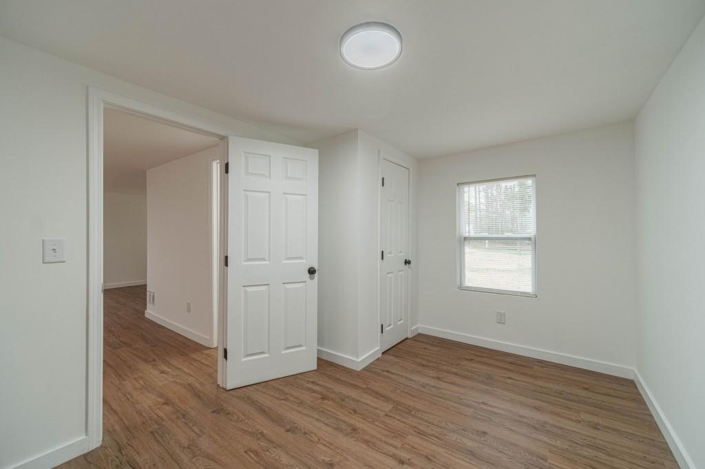 3617 Bob White Lane Southwest Loganville, GA 30052 - Photo 25 of 48 a view of an empty room with wooden floor and a window