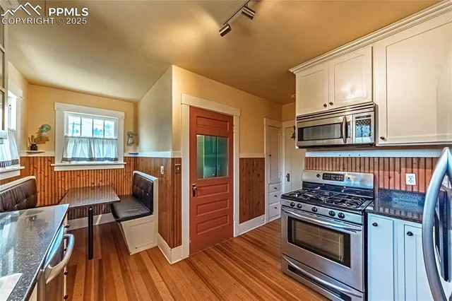a kitchen with wooden floors and appliances
