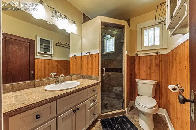 a bathroom with a granite countertop sink toilet and shower