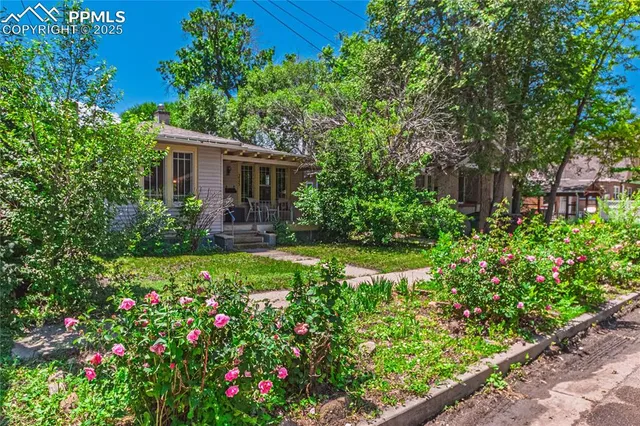 a view of a house with lots of flower garden