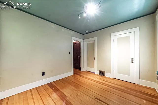 a view of empty room with wooden floor