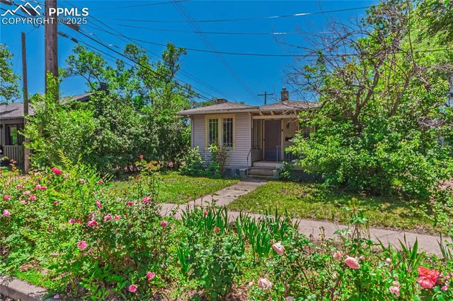 a view of a house with a yard and garden