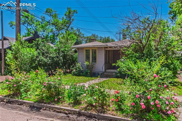 a view of a house with a yard and garden