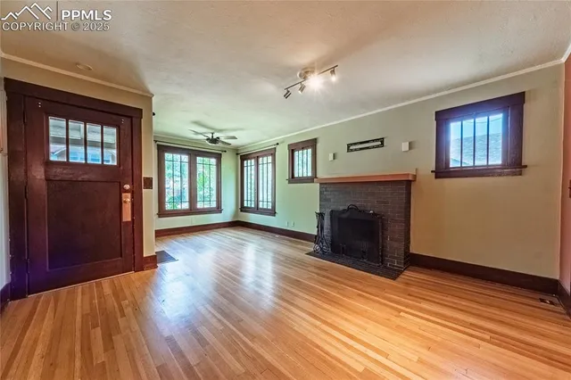 a view of a livingroom with wooden floor and a fireplace