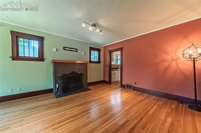 a view of an empty room with window and fire place