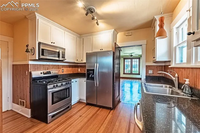 a kitchen with stainless steel appliances granite countertop a stove top oven a refrigerator and a microwave