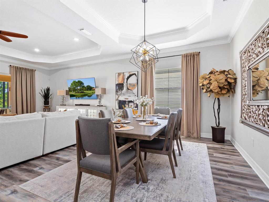 16532 Hillside Circle Lakewood Ranch, FL 34202 - Photo 14 of 67 a view of a dining room with furniture a chandelier and wooden floor