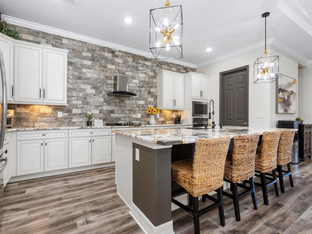 16532 Hillside Circle Lakewood Ranch, FL 34202 - Photo 16 of 67 a kitchen with a dining table chairs sink and cabinets