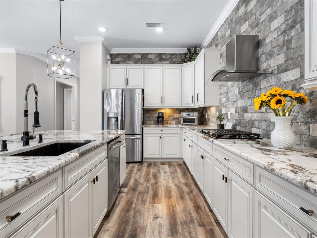 16532 Hillside Circle Lakewood Ranch, FL 34202 - Photo 19 of 67 a large kitchen with stainless steel appliances granite countertop a stove refrigerator and cabinets