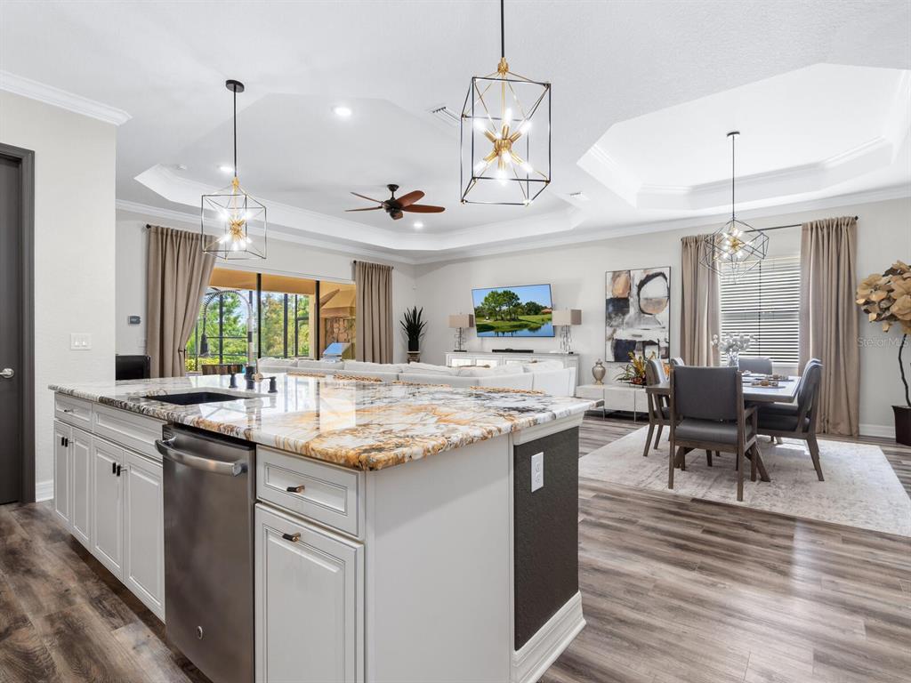 16532 Hillside Circle Lakewood Ranch, FL 34202 - Photo 21 of 67 a kitchen with stainless steel appliances granite countertop stove a table and chairs in it