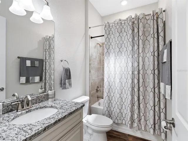 a bathroom with a granite countertop sink toilet and shower
