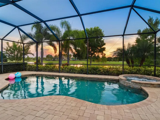 a view of a house with a big yard plants and palm trees