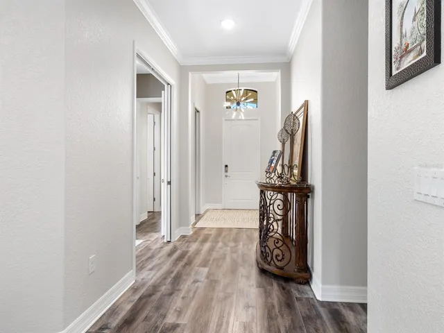 a living room with furniture kitchen view and a chandelier