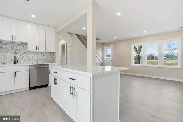 a kitchen with a sink cabinets and wooden floor