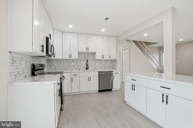 a kitchen with stainless steel appliances granite countertop a stove a sink and a refrigerator