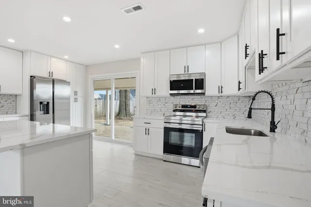 a kitchen with a refrigerator a sink and cabinets
