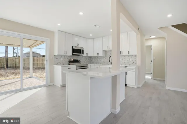a open kitchen with white cabinets and stainless steel appliances