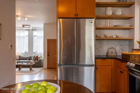 a kitchen with stainless steel appliances a refrigerator a stove a sink and a refrigerator with wooden floor