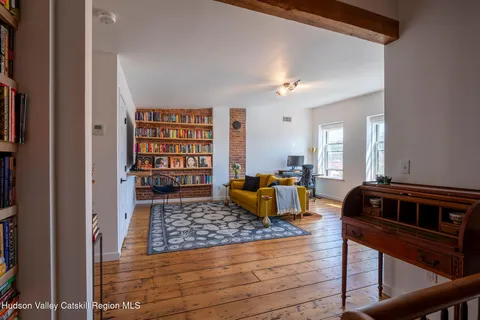 a living room with furniture and a book shelf