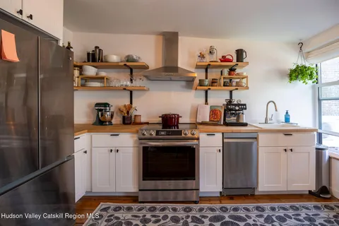 a kitchen with stainless steel appliances granite countertop a refrigerator and a stove