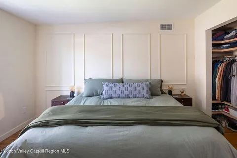 a bedroom with a bed and a flat tv screen on a dresser