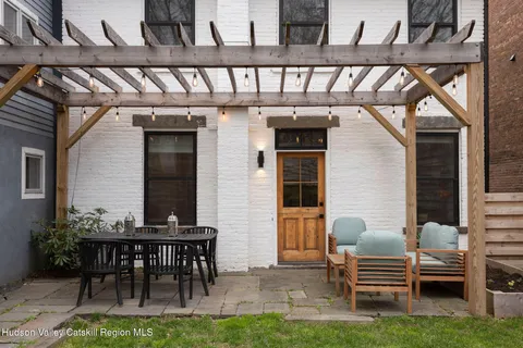 a view of backyard with seating space and wooden fence