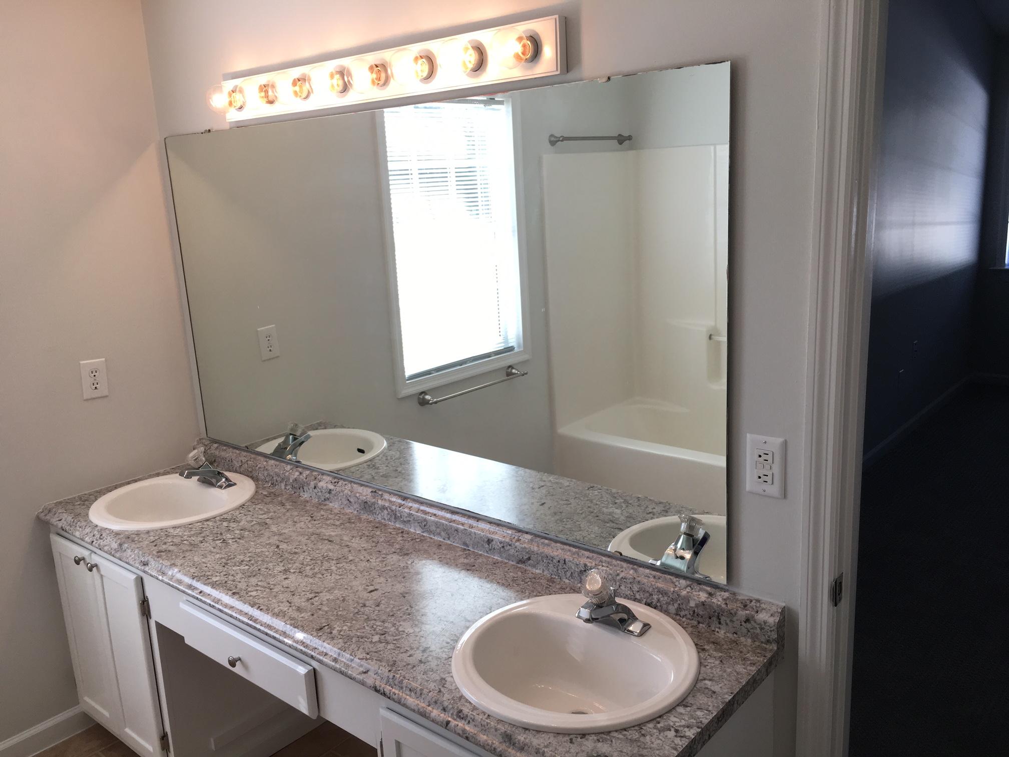 1650 Dickerson Road Goodview, VA 24095 - Photo 17 of 30 a bathroom with a granite countertop sink a mirror and a bathtub