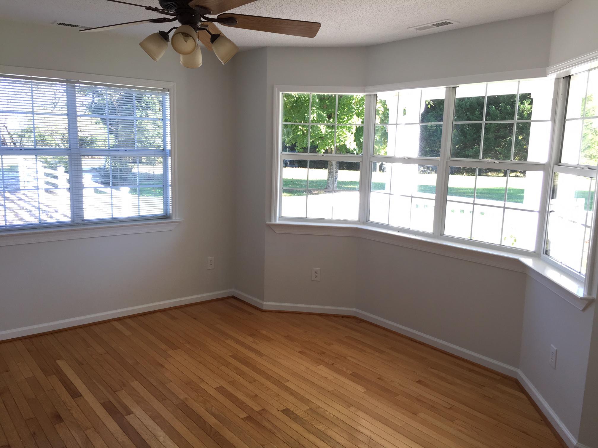 1650 Dickerson Road Goodview, VA 24095 - Photo 4 of 30 an empty room with wooden floor fan and windows
