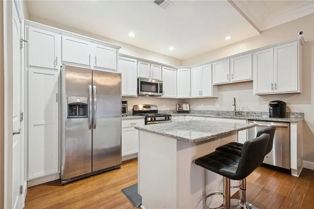 a kitchen with granite countertop a refrigerator stove top oven and sink
