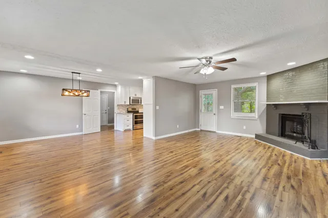 a view of an empty room with a fireplace and a window