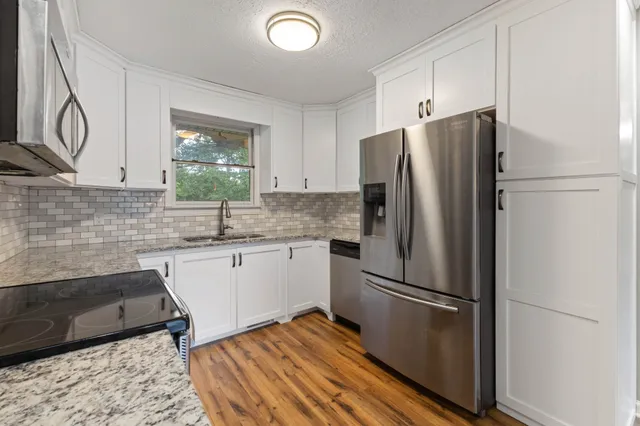 a kitchen with stainless steel appliances a refrigerator sink and cabinets