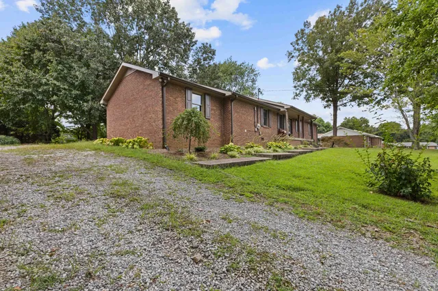 a backyard of a house with garden and barbeque oven