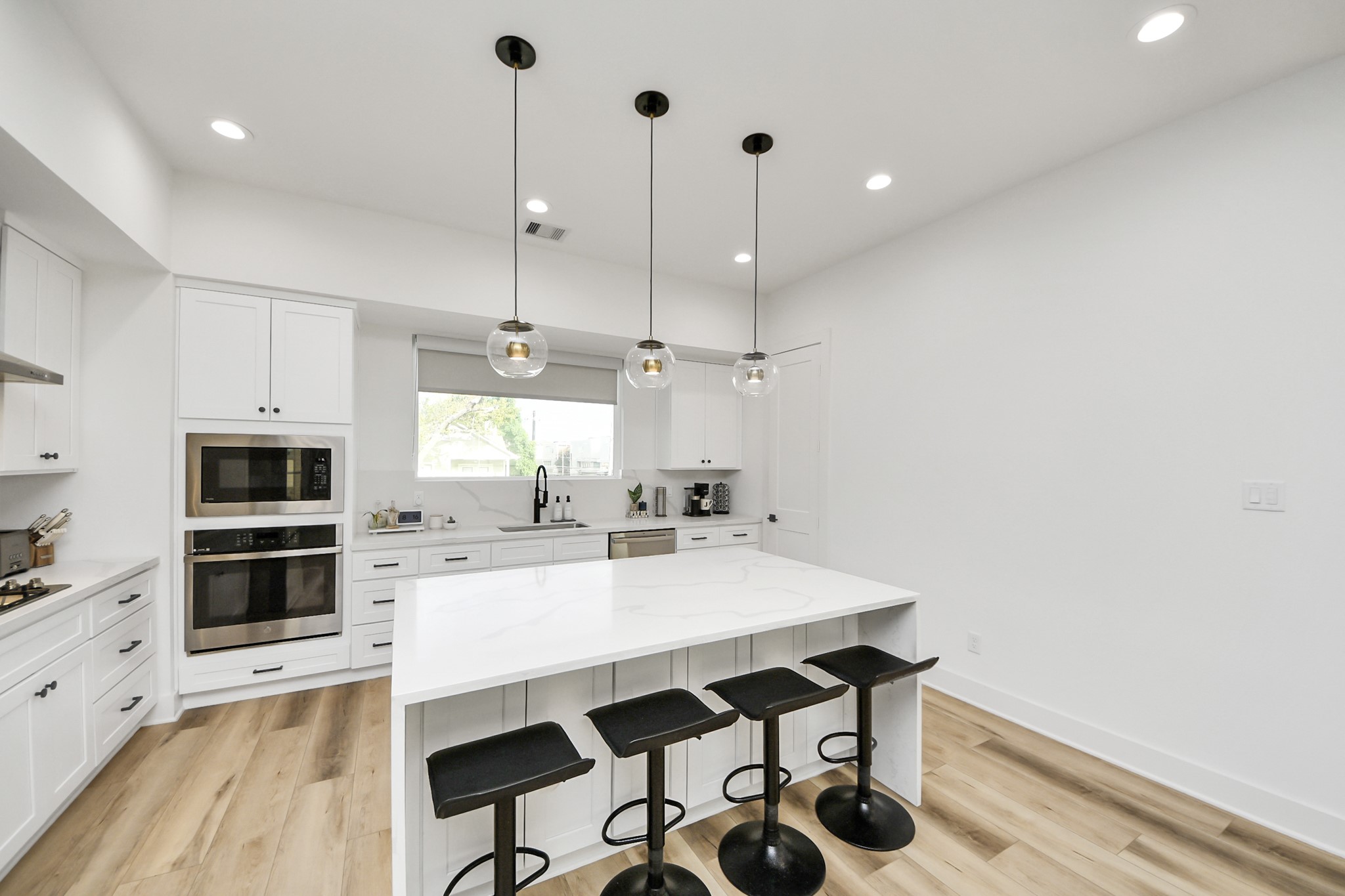 1044 West 17th Street Houston, TX 77008 - Photo 21 of 48 a kitchen with kitchen island a stove a chandelier and a refrigerator