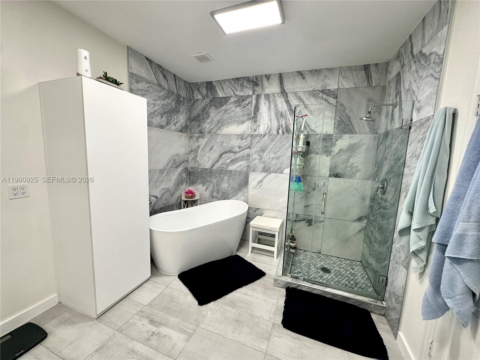 5790 Coach House Circle, Unit E Boca Raton, FL 33486 - Photo 32 of 65 a bathroom with a sink a toilet a shower and a mirror