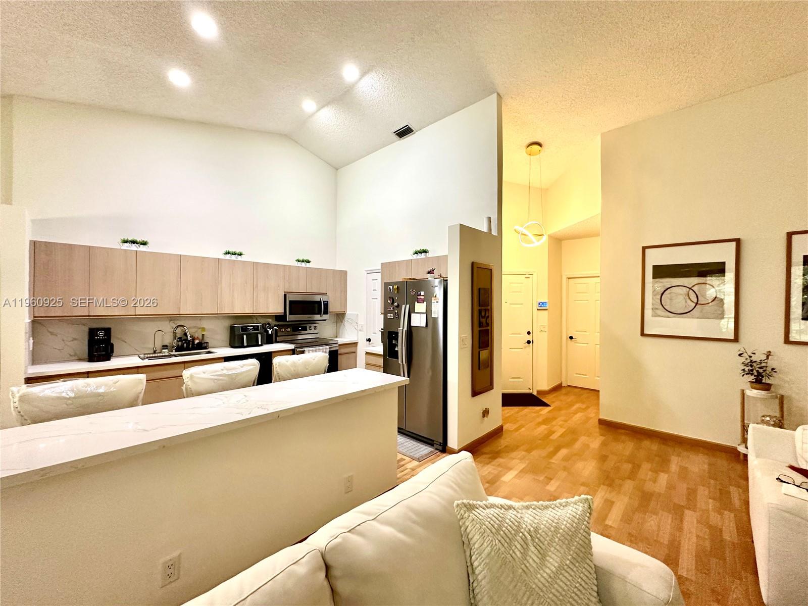 5790 Coach House Circle, Unit E Boca Raton, FL 33486 - Photo 9 of 65 a large white kitchen with a refrigerator a stove and a sink