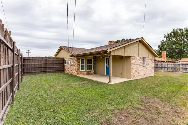 a view of a house with a yard and fence