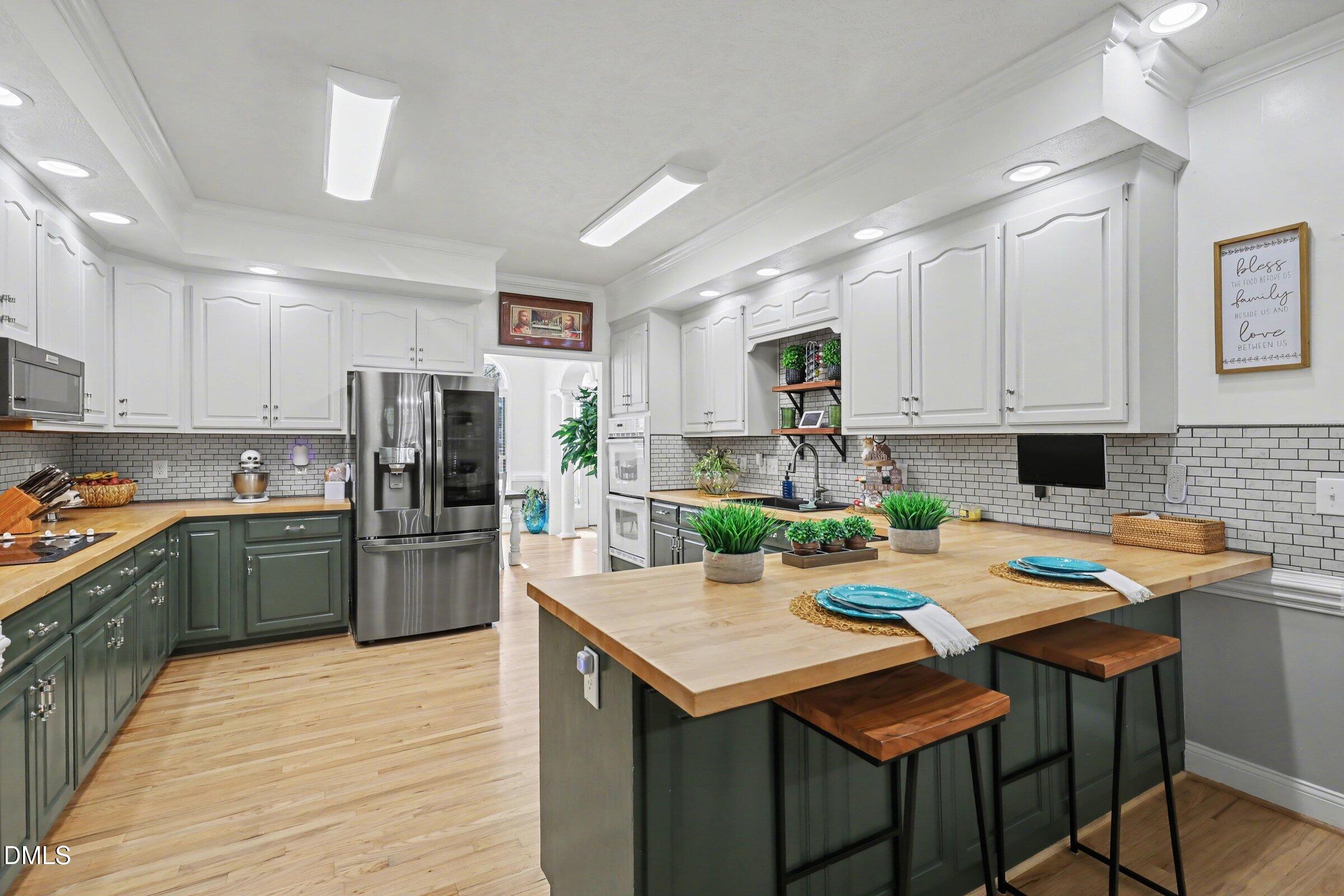 430 Fred Hall Road Stedman, NC 28391 - Photo 16 of 63 a kitchen with granite countertop a table chairs stove and refrigerator