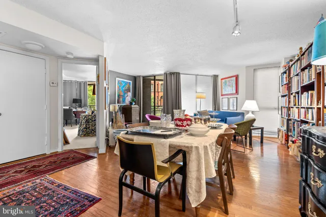 a view of a dining room and livingroom with furniture wooden floor a rug and a chandelier