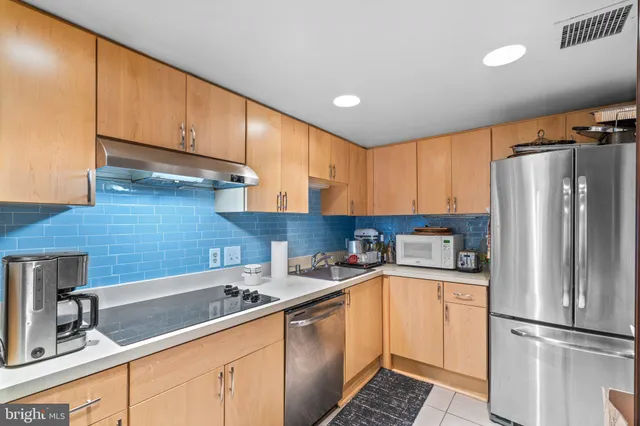 a kitchen with a sink a refrigerator and cabinets