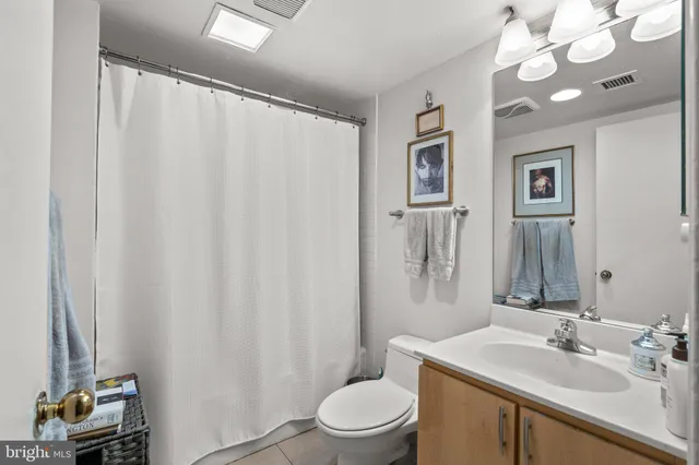 a bathroom with a sink vanity mirror and toilet