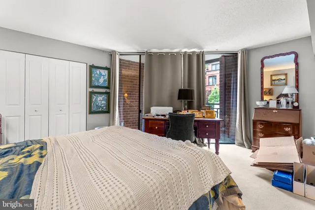 a bedroom with a bed and large windows