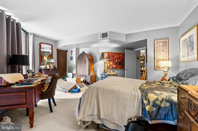 a bedroom with a bed and large windows