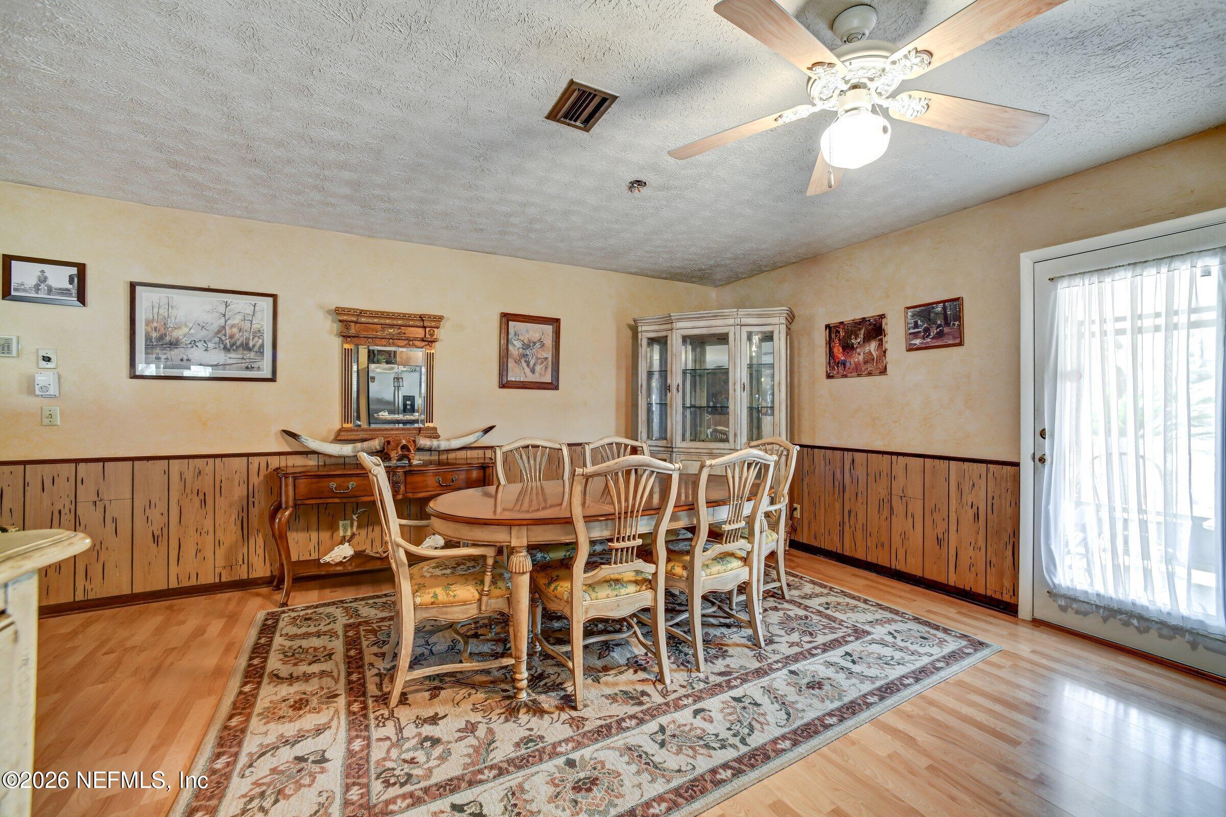 12790 Allport Road Jacksonville, FL 32258 - Photo 21 of 39 a dining room with wooden floor and a chandelier