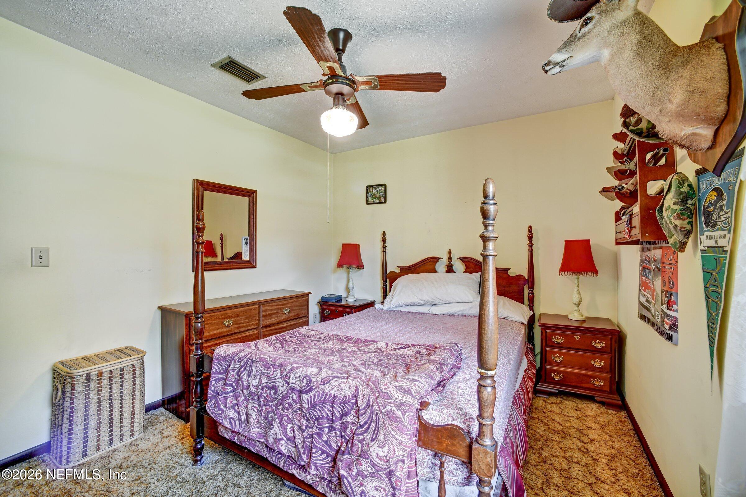 12790 Allport Road Jacksonville, FL 32258 - Photo 29 of 39 a bedroom with a bed and a chandelier
