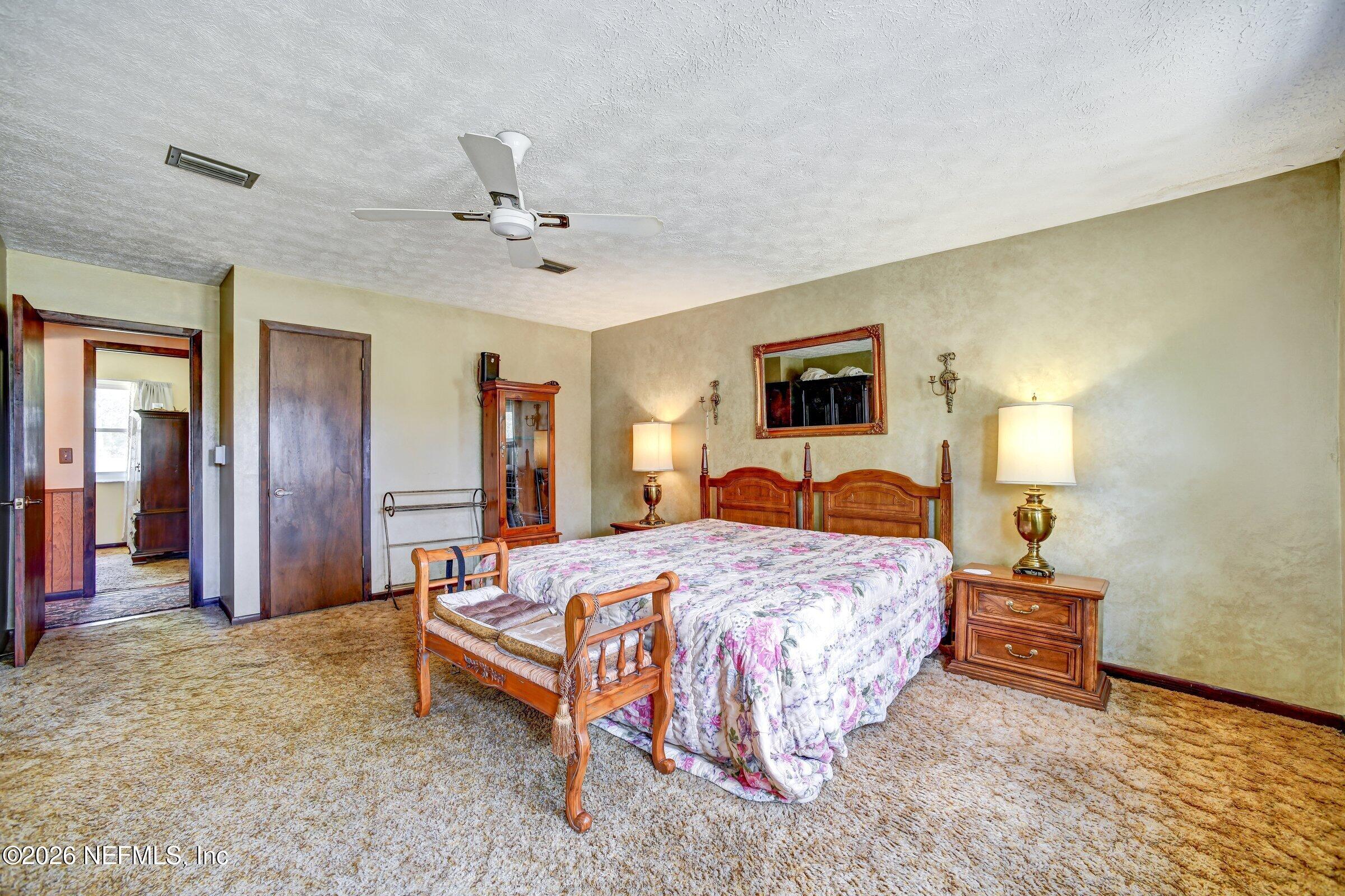 12790 Allport Road Jacksonville, FL 32258 - Photo 32 of 39 a bedroom with a bed and a chandelier