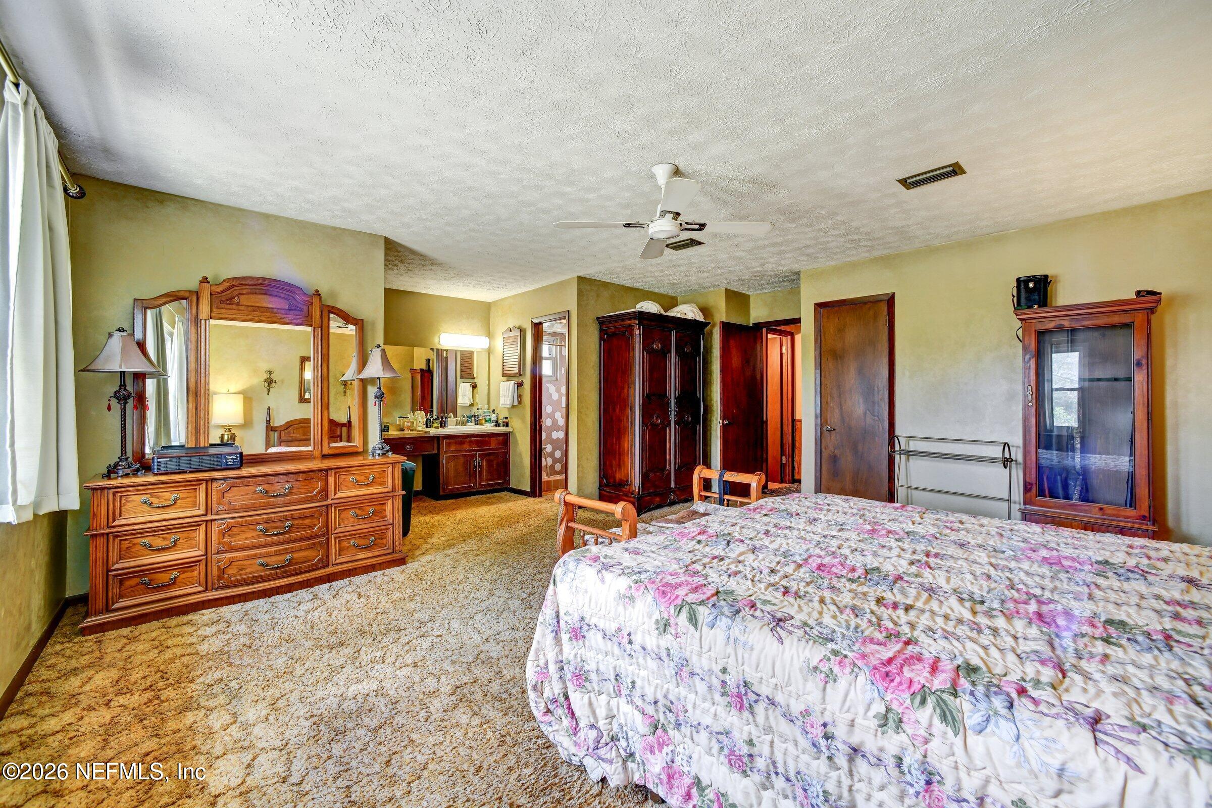 12790 Allport Road Jacksonville, FL 32258 - Photo 33 of 39 a bedroom with a large bed and dresser with mirror