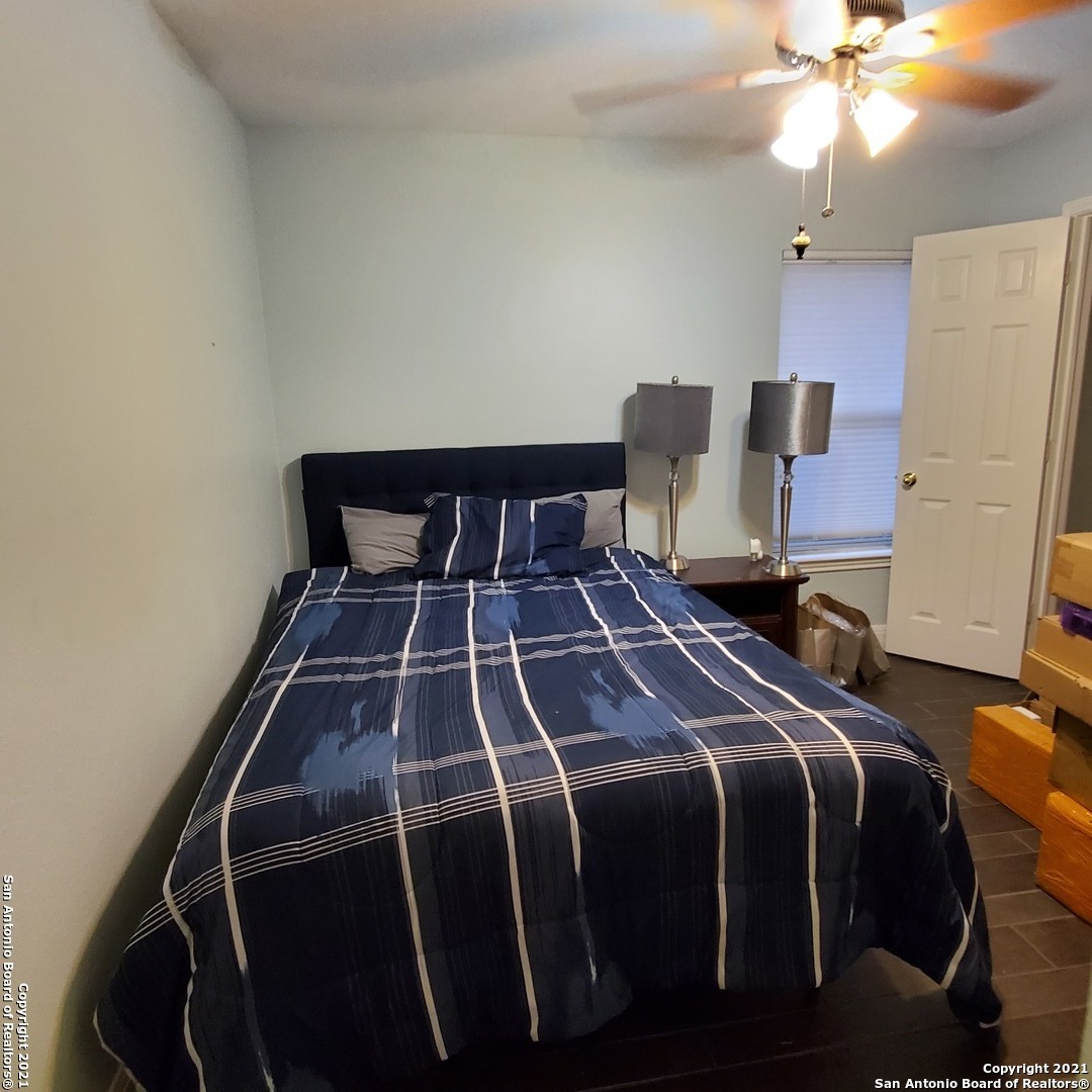 5922 Hart Field San Antonio, TX 78249 - Photo 17 of 21 a bedroom with a bed and a chandelier