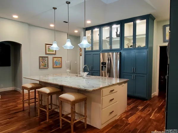 a kitchen with stainless steel appliances granite countertop a kitchen island a stove and a refrigerator