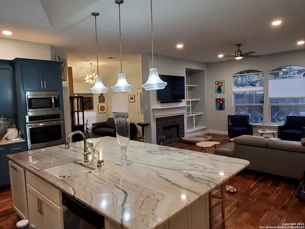 a open kitchen with sink a refrigerator and chairs