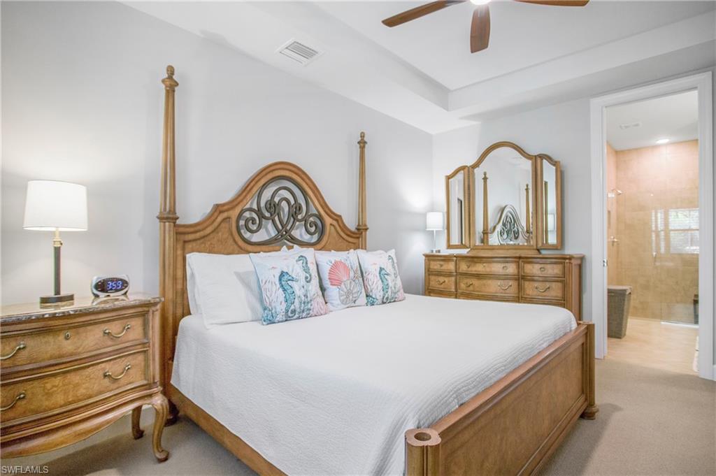 7674 Jacaranda Lane Naples, FL 34114 - Photo 8 of 45 a bedroom with a bed and a lamp on dresser